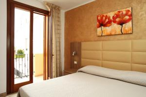 圣维托罗卡波Coralia Bed & Breakfast的卧室配有一张床,墙上挂有绘画作品