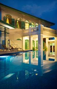 马六甲The Majestic Malacca Hotel - Small Luxury Hotels of the World的夜间带游泳池的别墅