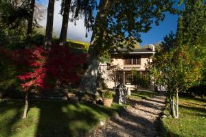 特伦托Villa Sizzo Relais B&B的一座树木繁茂的院子中的房子