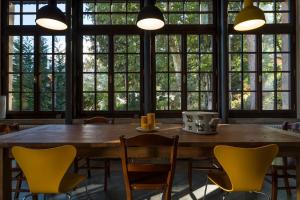 特伦托Villa Sizzo Relais B&B的窗户客房内的大桌子和椅子