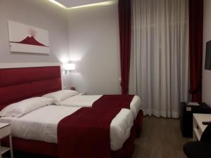 那不勒斯Gea suite的酒店客房设有一张大床和红色床头板