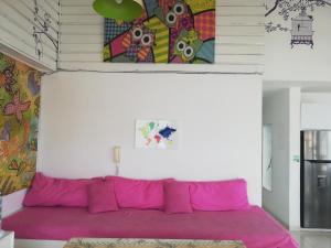 圣安德烈斯Edificio Santa Catalina 602的墙上画画的房间里一张粉红色的沙发