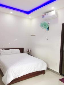 岘港Motel Thanh Long的卧室配有白色床和蓝色天花板