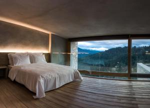卡尔派尼西翁Escapade Luxury Residences的一间卧室设有一张床和一个大窗户