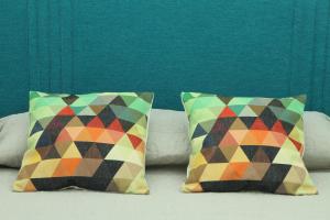维迪盖拉Casa da Matriz的床上的两张色彩缤纷的枕头,设有绿色的墙壁