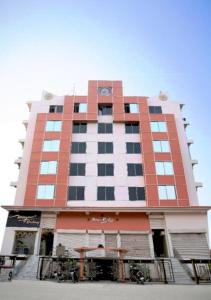 古瓦哈提Mayur Residency Hotel的一座高大的红色和白色建筑,设有阳台
