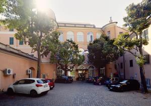 热那亚米迪特拉奈酒店的一座大型建筑,前面有汽车停放