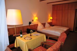 瓦门施泰纳赫WAGNERS Hotel im Fichtelgebirge的酒店客房配有一张床和一张带台灯的桌子