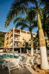 巴亚索拉诺Hotel Costa Choco的一个带游泳池、棕榈树和椅子的度假酒店