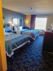 PocahontasDays Inn & Suites by Wyndham Pocahontas的酒店客房设有两张床和一台平面电视。