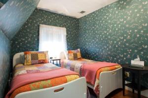 布鲁克林布鲁克林柯立芝角落住宿加早餐宾馆的卧室设有两张床,卧室拥有带鲜花的绿色墙壁