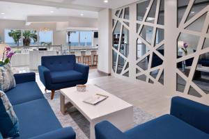 默特尔比奇Cabana Shores Hotel的客厅配有蓝色的椅子和桌子
