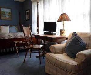 奥斯汀Strickland Arms Bed and Breakfast的客厅配有书桌、电脑和沙发