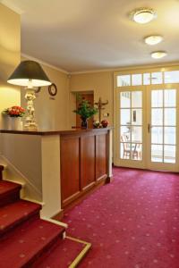 波兹南黄金酒店的一间铺有红色地毯并带楼梯的客厅