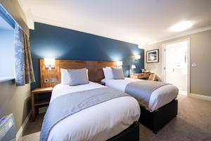 布罗姆利Toby Carvery Beckenham by Innkeeper's Collection的酒店客房设有两张床和蓝色的墙壁。