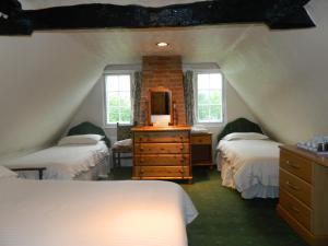 斯托马基特The Cedars Hotel的阁楼卧室配有两张床和一个带镜子的梳妆台