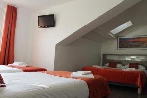 苏斯通Hôtel du Centre的一间酒店客房,设有两张床和电视
