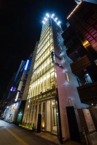 东京Tosei Hotel Cocone Ueno的一座高大的建筑,晚上有顶灯