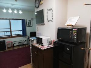 札幌ALMAZ PLACE #203的办公室,配有书桌、电脑和微波炉