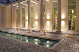 那不勒斯艾瑟达帕拉佐酒店的享有带游泳池的大楼大堂的景致