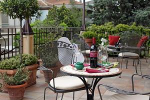 里米尼Hotel Villa Irma的庭院配有椅子和一张桌子及一瓶葡萄酒