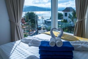 班拉克海滩Celebrity Ocean View Villa Samui的一间卧室配有带毛巾的床和窗户。