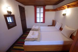 波兹思Guest house Maria Savekova 19 c.的一间卧室设有两张床、一张桌子和一个窗口