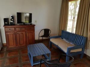 伊图萨因戈Rancho Aparte的客厅设有蓝色长椅和电视。