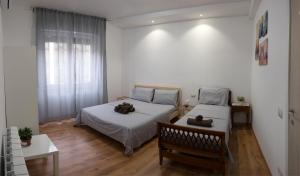帕多瓦CASAMINA的一间卧室设有两张床、一张长凳和一个窗户。