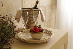 马利耶格拉奈科特酒店的一张桌子,上面放着一碗草莓和一瓶葡萄酒