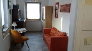 伦斯泰格地区施米德费尔德Rennsteigwohnung Rust的客厅配有红色的沙发、桌子和窗户