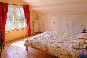Cul-des-SartsLa maison du lac的一间卧室设有一张床和一个大窗户
