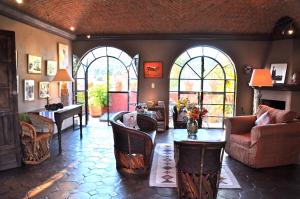 圣米格尔-德阿连德Casa de la Cuesta B&B的客厅配有椅子和桌子,设有窗户