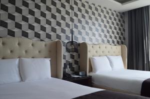 帕丘卡德索托Casa Basalto的配有 ⁇ 面墙的酒店客房的两张床