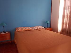 拉马约Las Casitas de Emilia的一间卧室配有一张蓝色墙壁的床