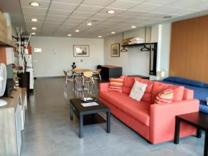 罗萨里奥港Studio Loft Fuerteventura的客厅配有红色的沙发和桌子