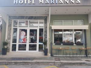 亚历山德鲁波利斯玛丽安娜酒店的酒店码头在大楼前设有2张桌子和椅子