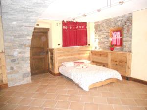 Verrayes奥库尔旅馆的一间卧室设有一张床和石墙