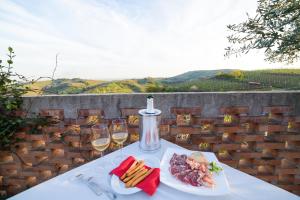 Monteforte dʼAlponeAgriturismo la Preara的一张桌子,上面放着两杯葡萄酒和一盘食物