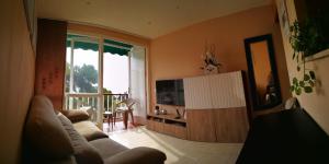 滨海圣波尔White Stones Beach In Sant Pol de Mar的带沙发和电视的客厅