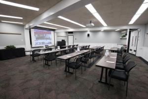 新不伦瑞克罗格斯大学客栈和会议中心酒店的配有桌椅和投影屏幕的教室