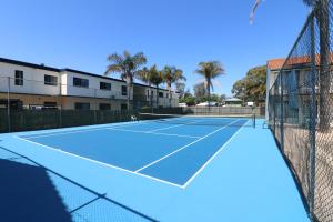 梅林布拉爱奎瑞斯美瑞布拉度假村的一座带网和棕榈树的网球场