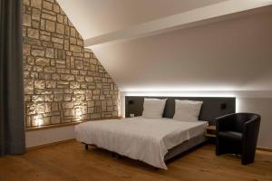 佩尔Wein Erlebnis Hotel Maimühle的一间卧室设有一张床和石墙
