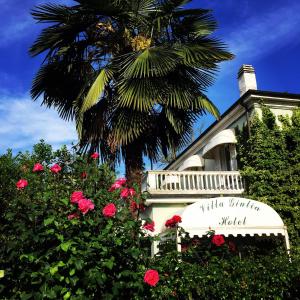 托尔托纳茱莉亚别墅酒店的玫瑰花楼前的棕榈树
