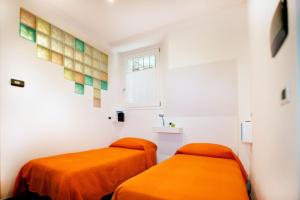 大圣玛丽亚Appartamento Melissa的白色客房的两张橙色床,设有窗户