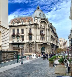 布加勒斯特NF Palace Old City Bucharest的街上的大建筑,前面的人在走