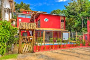 伊塔卡雷i9 Embaú Flats & Suites的红色的房子,设有围栏和游泳池