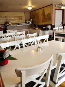 图什比比奥尼德特酒店的餐厅里一张白色的桌子和椅子