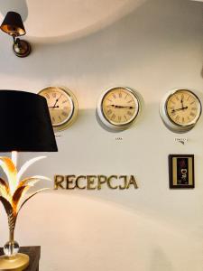韦巴Hotel Gołąbek的墙上有三个钟,上面写着“reederaria”这个词