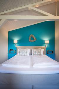 圣彼得奥尔丁Hotel kleine Auszeit - Adults Only的一张白色大床,拥有蓝色的墙面